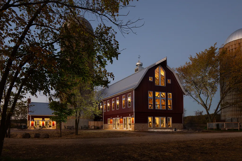 Four Winds Barn at dusk, with the restored silos
