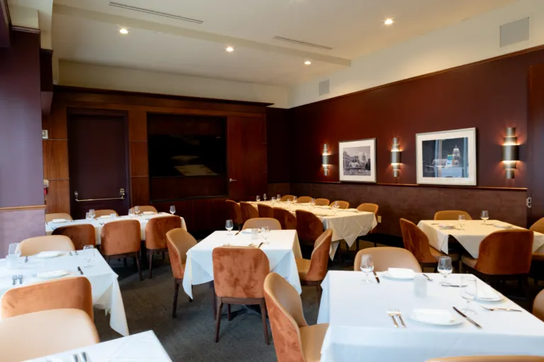 Private dining room at Johnny Delmonico's with a wood-panelled media wall
