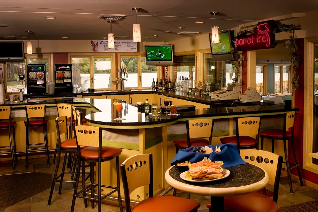A bar and lounge area with high seating and warm lighting